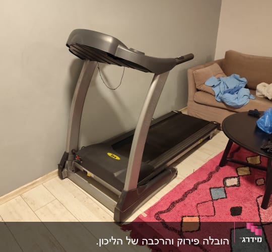 הליכון בחדר עם שטיח צבעוני ושולחן קטן